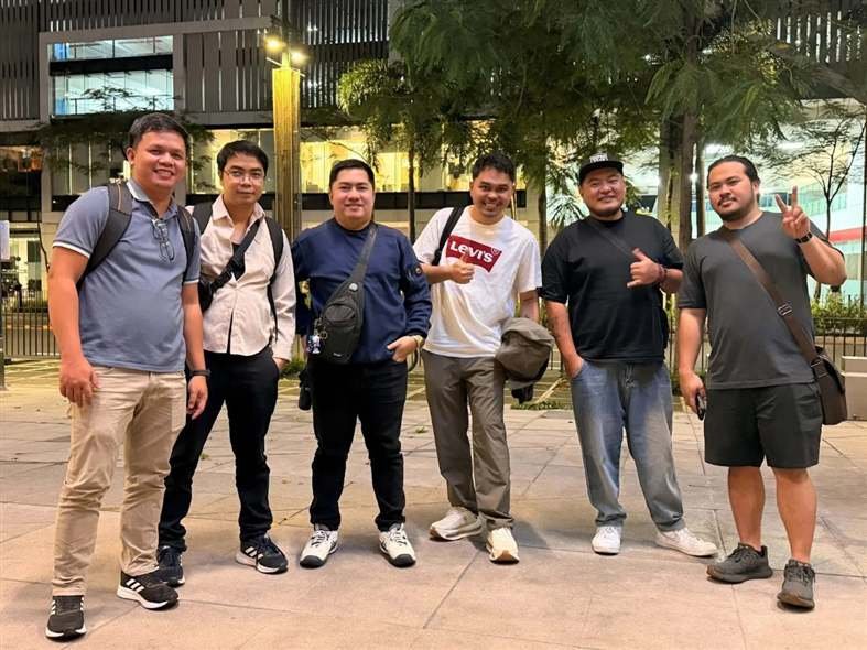 Six SEO meetup attendees posing outdoors in Ortigas Center at night after the Kita Tayo event